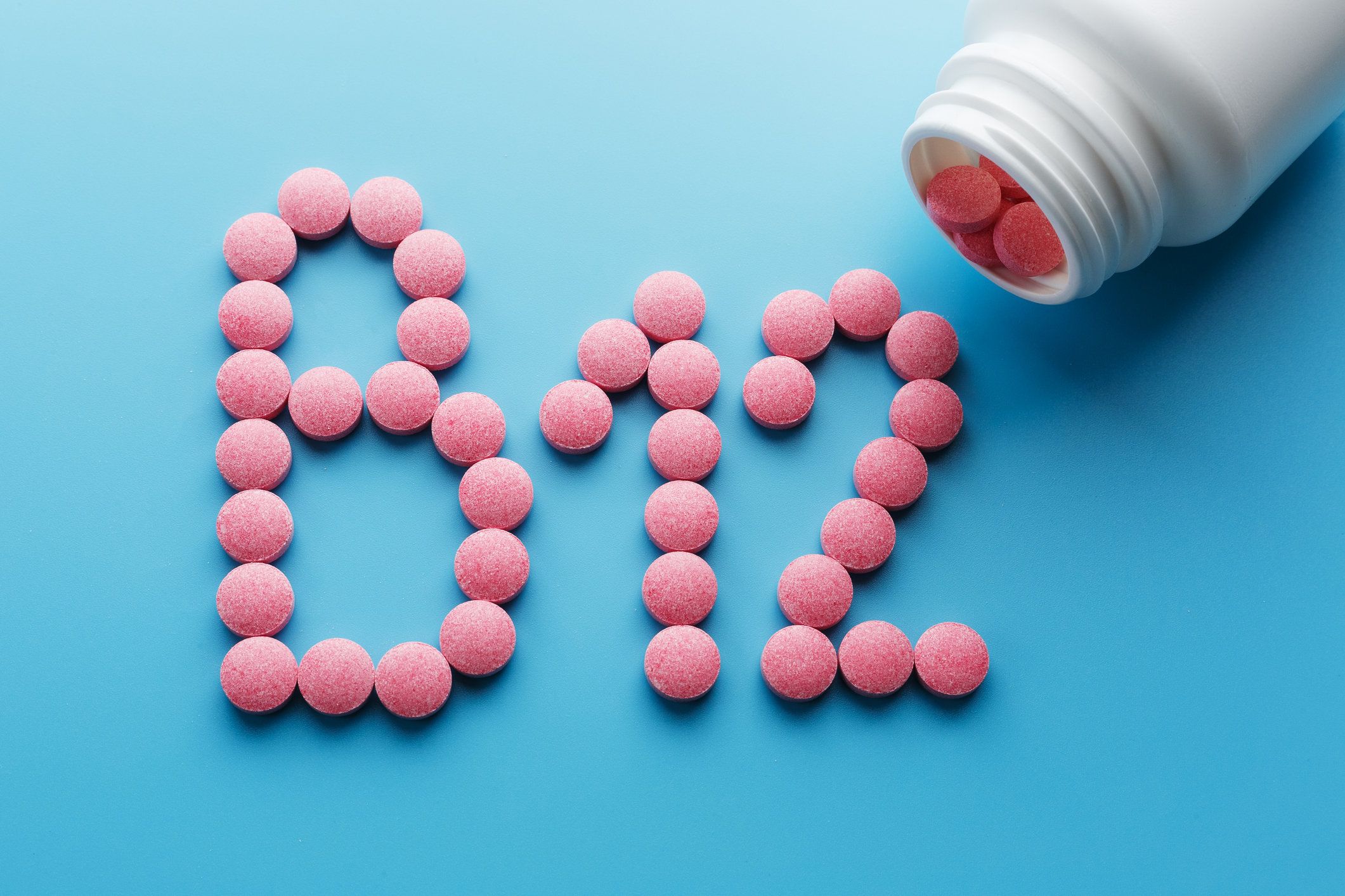 Pink pills on a blue background that spell out "B12"