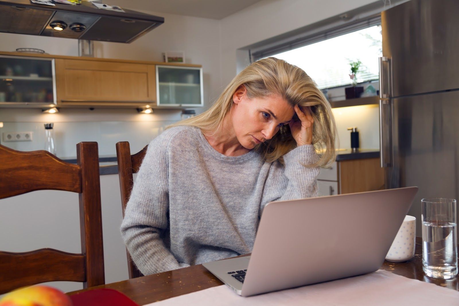 woman in her kitchen on her laptop